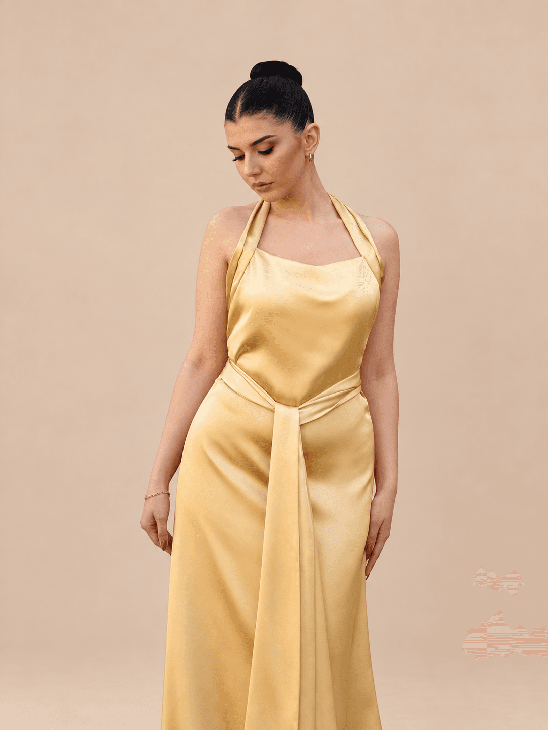Gold sash satin dress — front view, hands clasped